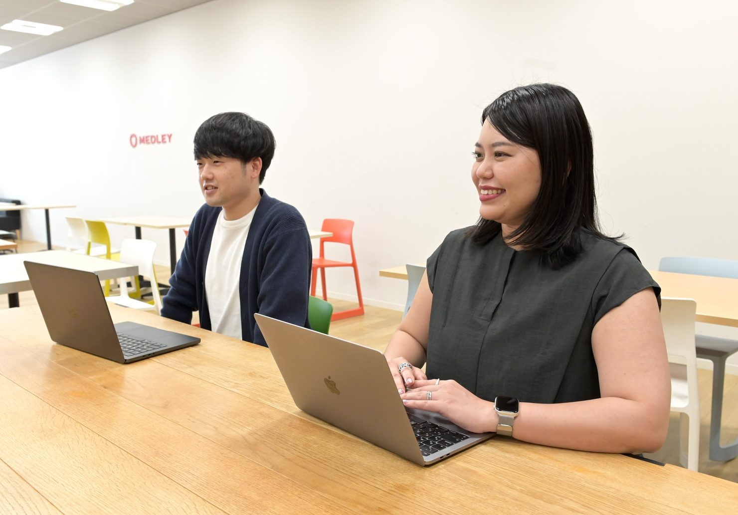 株式会社メドレーAI推進室の澤渡様・伊藤様がノートPCを操作しながら対談している様子を撮影した写真です
